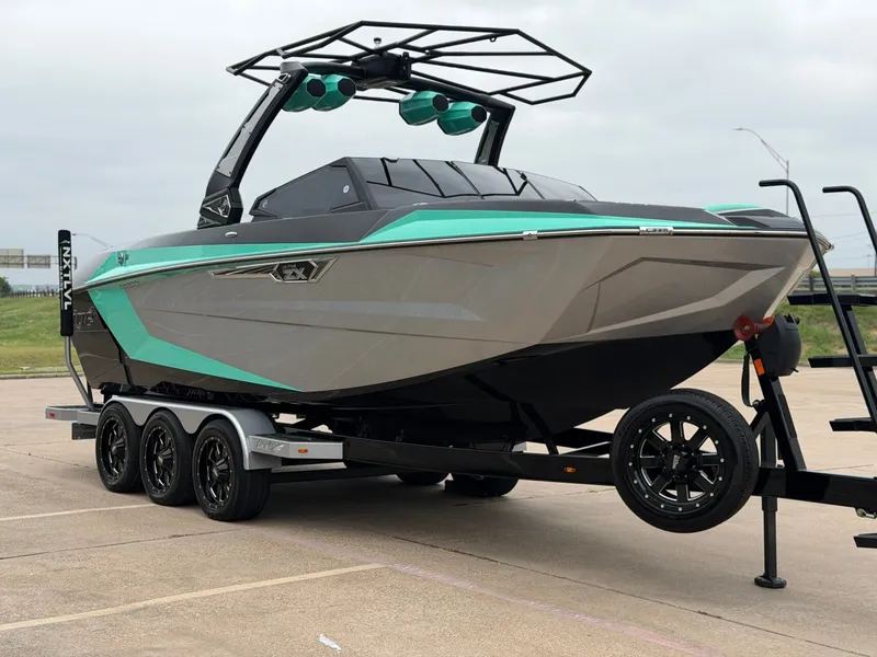 Slide: The Image of A modern 2025 Tigé Ultré 23ZX on a trailer, featuring striking turquoise accents. - 6