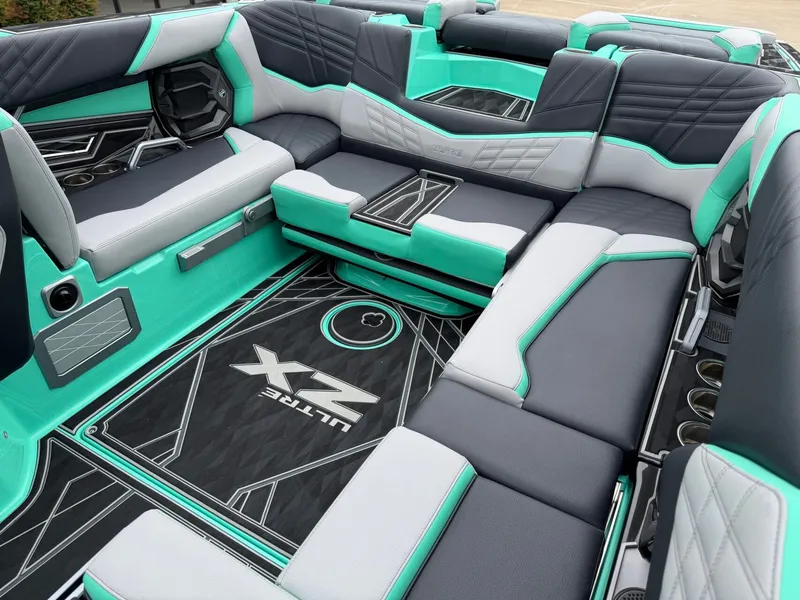 Slide: The Image of The image shows the luxurious interior of a Tigé Ultré 23ZX boat with turquoise and gray upholstery. - 13