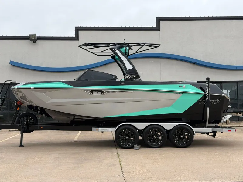 The Image of The image shows a 2025 Tigé Ultré 23ZX boat on a trailer, featuring turquoise accents. - 1