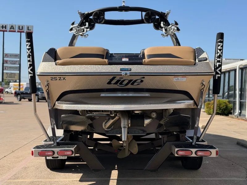 Slide: The Image of Rear view of a 2022 Tigé 25ZX boat with brown seats and black frame. - 5
