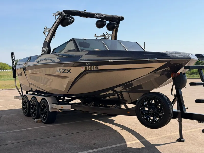 Slide: The Image of A 2022 Tigé 25ZX boat on a trailer, featuring a sleek black design and sturdy tower. - 7