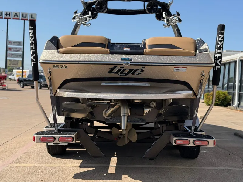 Slide: The Image of The image shows the rear of a 2022 Tigé 25ZX boat on a trailer. - 4