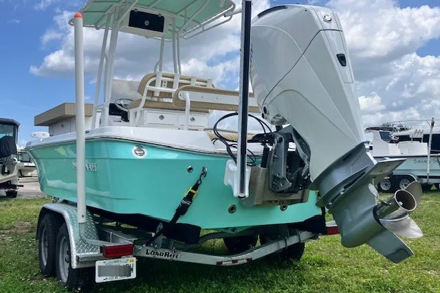 Slide: The Image of 2025 Savannah 220 IS boat on trailer, featuring a powerful outboard motor. - 2