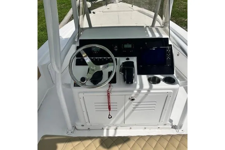 Slide: The Image of 2025 Savannah 220 IS boat console with steering wheel, controls, and cup holders. - 4