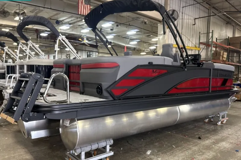 Slide: The Image of 2027 Bennington 22 M Open Fastback Quad Bench pontoon boat in a showroom. - 2