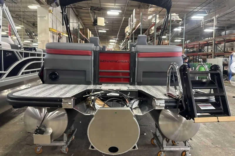 Slide: The Image of 2027 Bennington 22 M Open Fastback Quad Bench pontoon boat in a warehouse setting. - 7