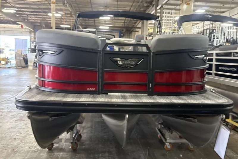 Slide: The Image of 2027 Bennington 22 M Open Fastback Quad Bench pontoon boat in a warehouse setting. - 3