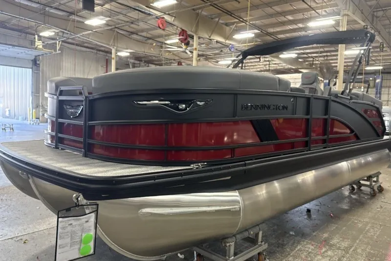 Slide: The Image of 2027 Bennington 22 M Open Fastback Quad Bench pontoon boat in a warehouse setting. - 4