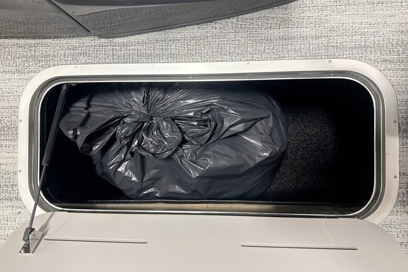 Slide: The Image of Storage compartment with black bag inside Bennington 22 M Open Fastback Quad Bench, 2027 model. - 11