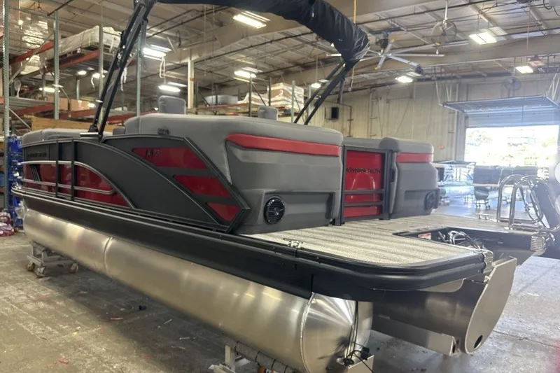 Slide: The Image of 2027 Bennington 22 M Open Fastback Quad Bench pontoon boat in a warehouse setting. - 6