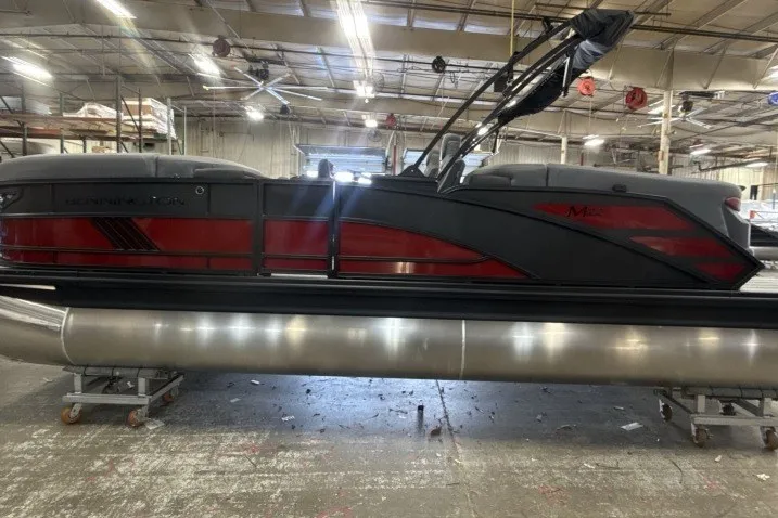 Slide: The Image of 2027 Bennington 22 M Open Fastback Quad Bench pontoon boat in a warehouse setting. - 5