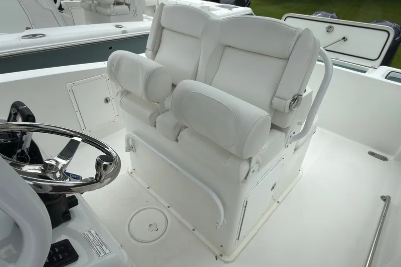 Slide: The Image of 2019 Sea Hunt Gamefish 27 boat interior with white captain's chair and steering wheel. - 17