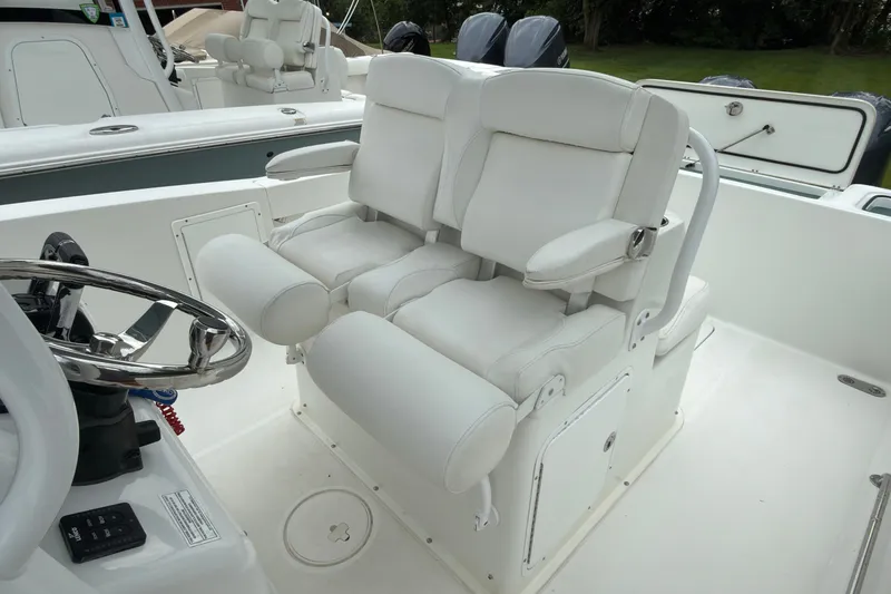 Slide: The Image of 2019 Sea Hunt Gamefish 27 boat with dual white captain's chairs and steering wheel. - 18