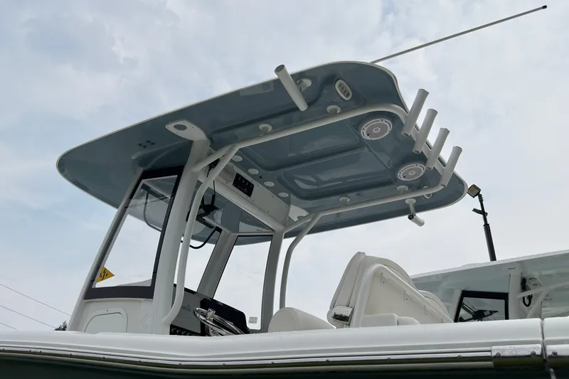 Slide: The Image of 2019 Sea Hunt Gamefish 27 boat with T-top and rod holders under cloudy sky. - 4