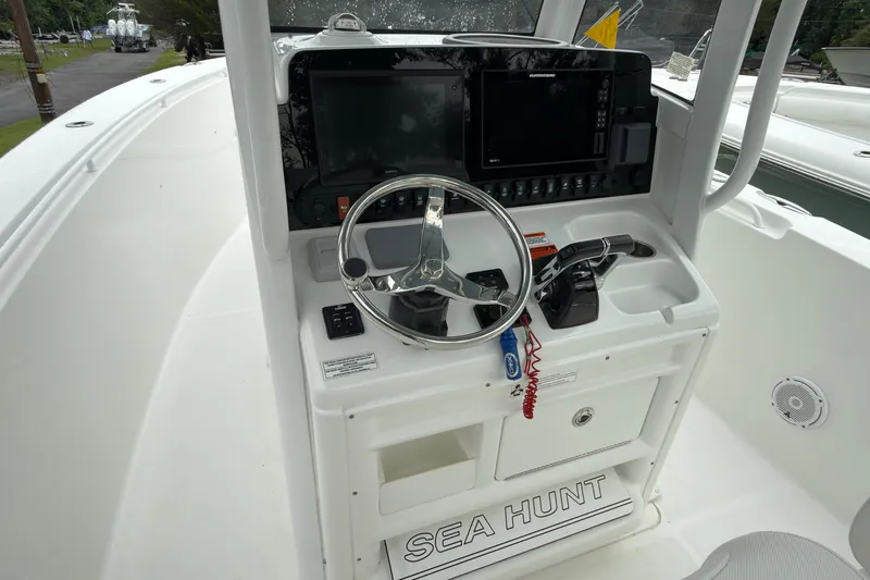 Slide: The Image of 2019 Sea Hunt Gamefish 27 boat console with steering wheel and navigation equipment. - 20