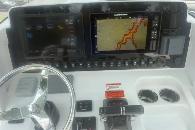 Slide: The Image of 2019 Sea Hunt Gamefish 27 dashboard with navigation screens and steering wheel. - 22
