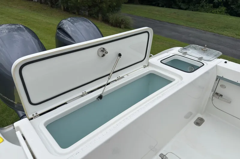 Slide: The Image of 2019 Sea Hunt Gamefish 27 boat with open storage compartments and dual engines. - 9