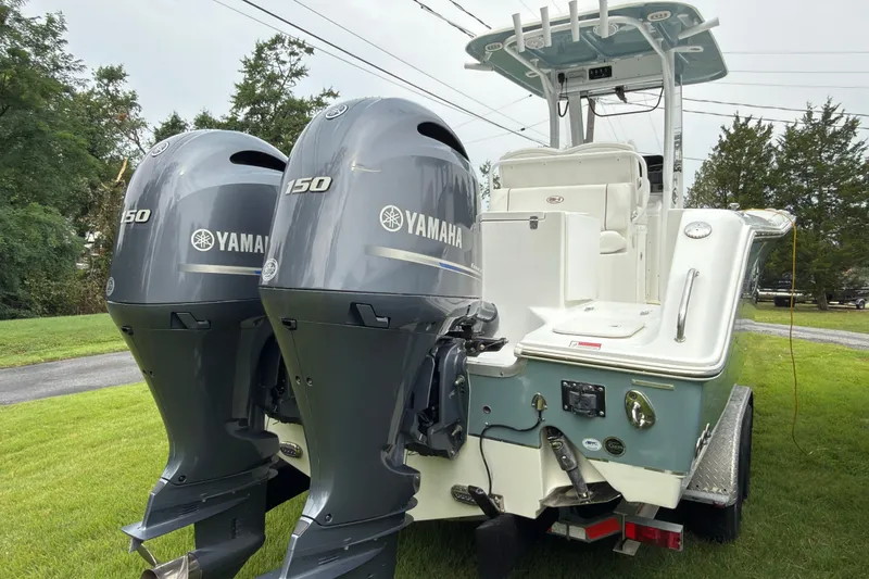 Slide: The Image of 2019 Sea Hunt Gamefish 27 boat with dual Yamaha 150 engines on a grassy area. - 5