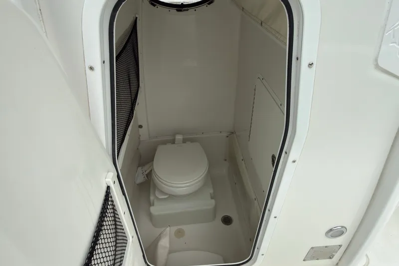 Slide: The Image of 2019 Sea Hunt Gamefish 27 boat interior with compact marine toilet. - 13
