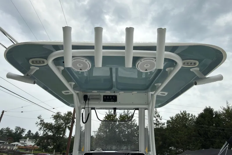 Slide: The Image of 2019 Sea Hunt Gamefish 27 T-top with rod holders and speakers, under cloudy sky. - 30