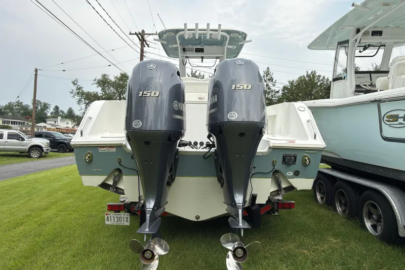 Slide: The Image of 2019 Sea Hunt Gamefish 27 with twin Yamaha 150 engines, parked on grass. - 6