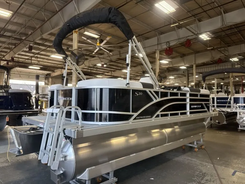 Slide: The Image of A Bennington pontoon boat, model 20 S1 STERN RADIUS, is in a warehouse. It features a sleek black and silver design. - 3