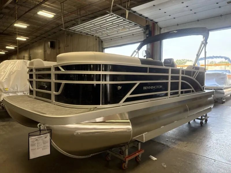 Slide: The Image of A Bennington pontoon boat is in a warehouse. It features a modern design with an open deck. - 4