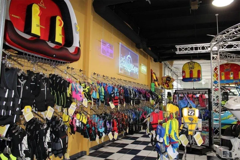 Slide: The Image of A store with a variety of colorful life jackets and wetsuits displayed on the walls. - 11
