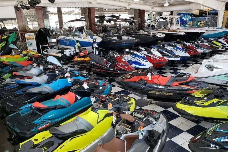 Slide: The Image of A showroom filled with colorful jet skis and boats on a black-and-white checkered floor. - 7