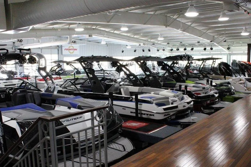 Slide: The Image of A showroom filled with boats featuring modern designs and various colors. The boats are closely lined up. - 6