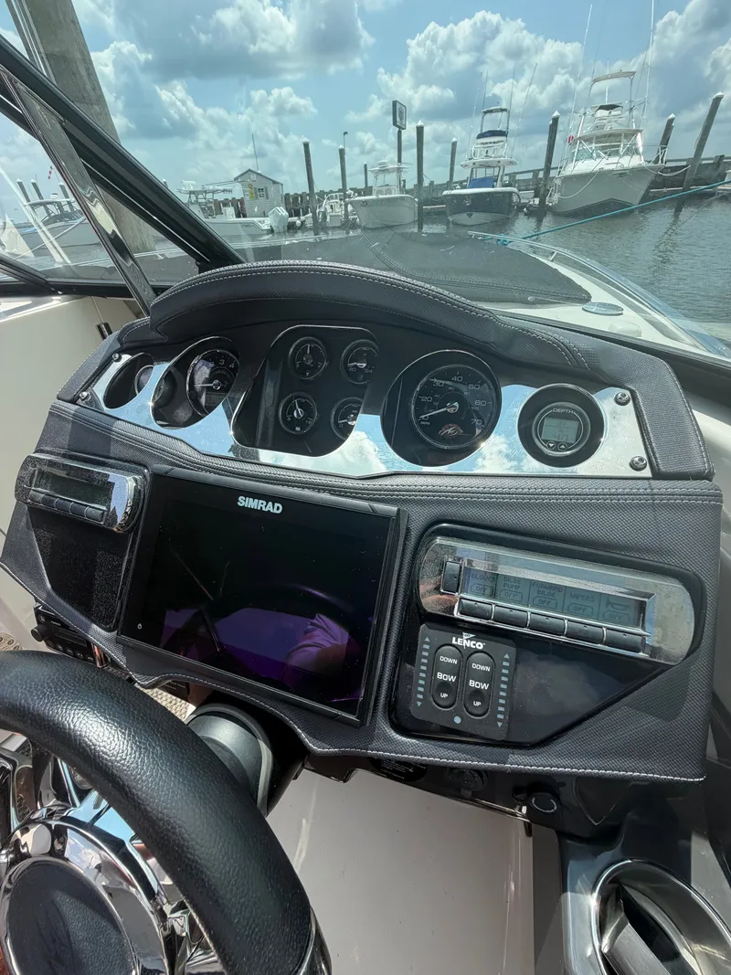 Slide: The Image of The dashboard of a 2013 Monterey 288SS Super Sport with multiple gauges and a Simrad display. - 12