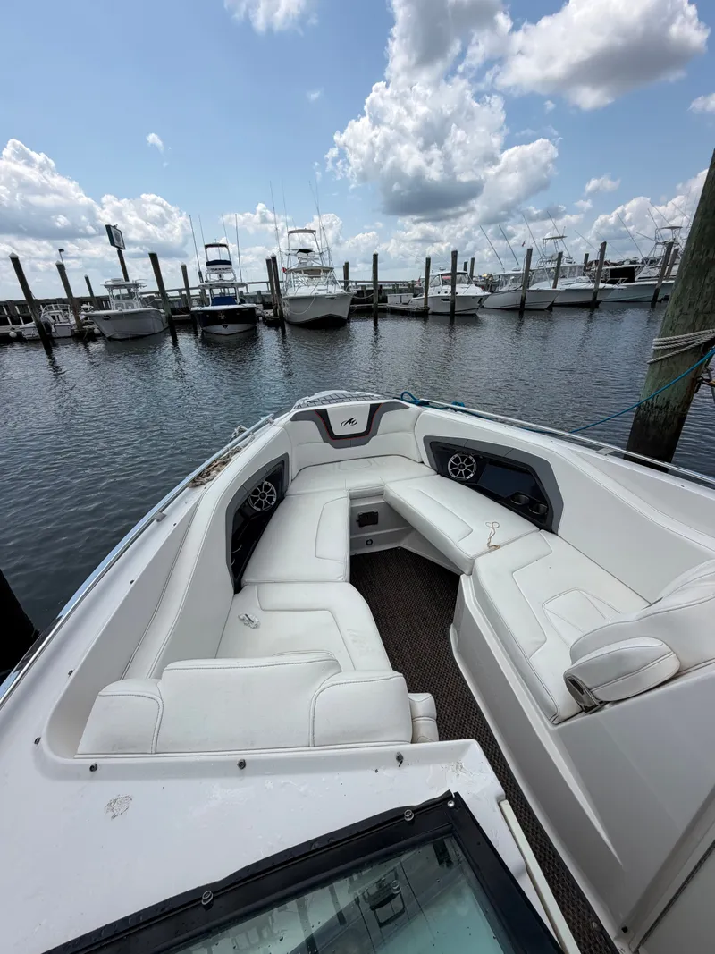 Slide: The Image of The image shows the bow seating area of a 2013 Monterey 288SS Super Sport boat docked at a marina. - 4