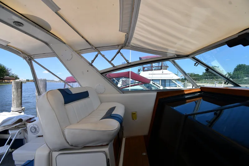 Slide: The Image of 1989 Sea Ray 390 Express Cruiser interior with white seating and waterfront view. - 15