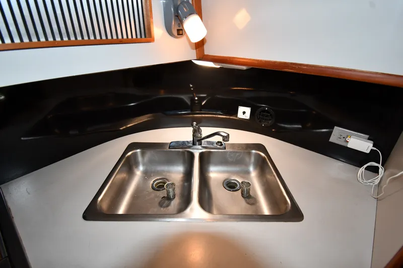 Slide: The Image of 1989 Sea Ray 390 Express Cruiser kitchen sink with dual basins and modern fixtures. - 34