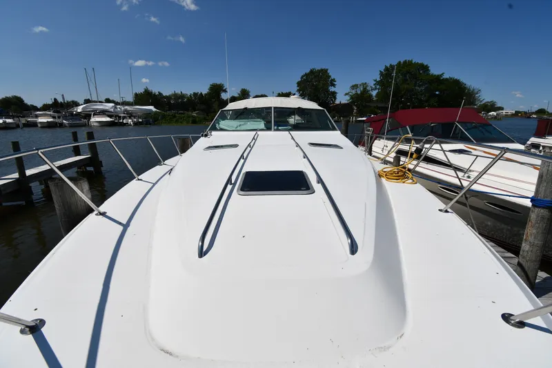 Slide: The Image of 1989 Sea Ray 390 Express Cruiser docked at marina under clear blue sky. - 6