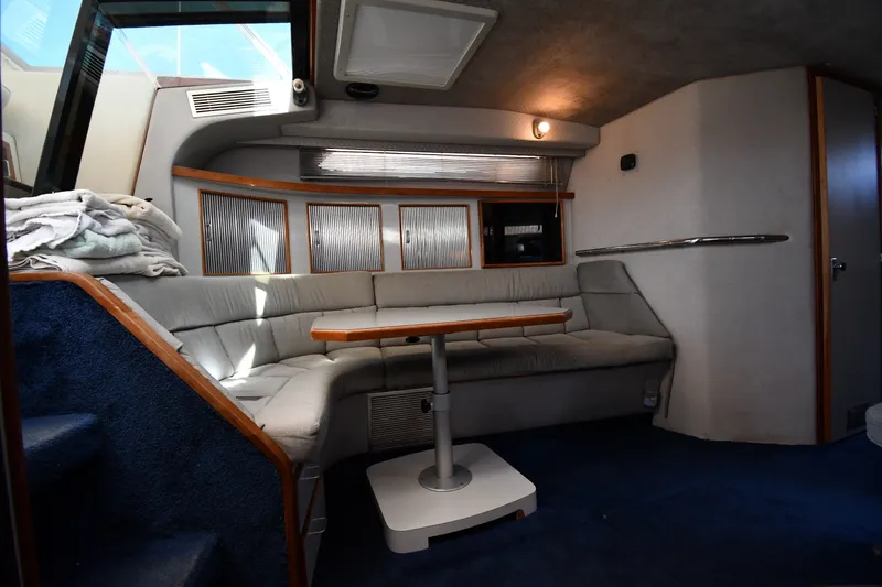 Slide: The Image of Interior of 1989 Sea Ray 390 Express Cruiser with cozy seating and wooden table. - 28