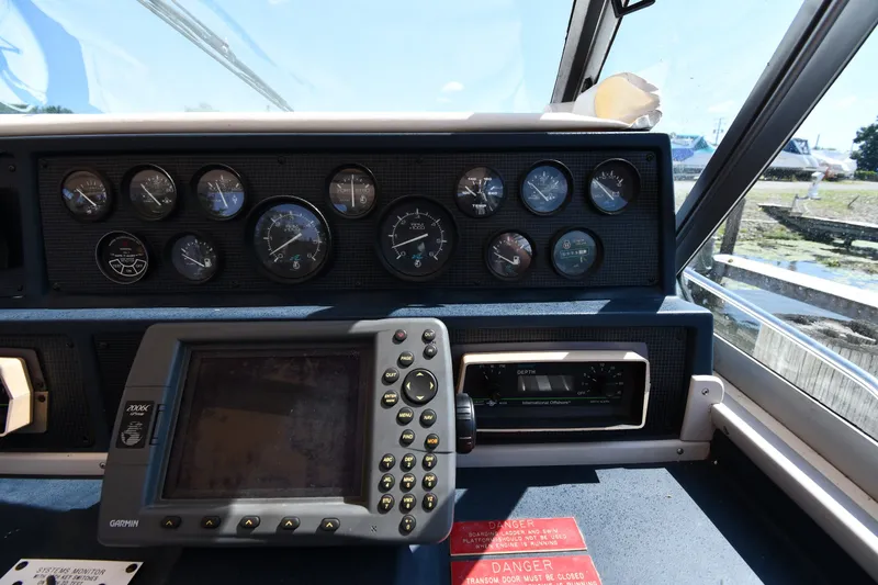 Slide: The Image of Dashboard of a 1989 Sea Ray 390 Express Cruiser with gauges and navigation equipment. - 12