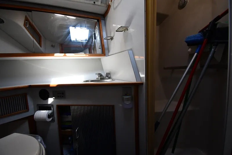 Slide: The Image of Interior of 1989 Sea Ray 390 Express Cruiser bathroom with sink, mirror, and shower. - 33