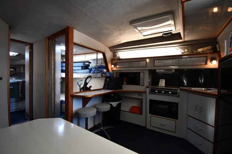Slide: The Image of Interior of 1989 Sea Ray 390 Express Cruiser with kitchen and seating area. - 27