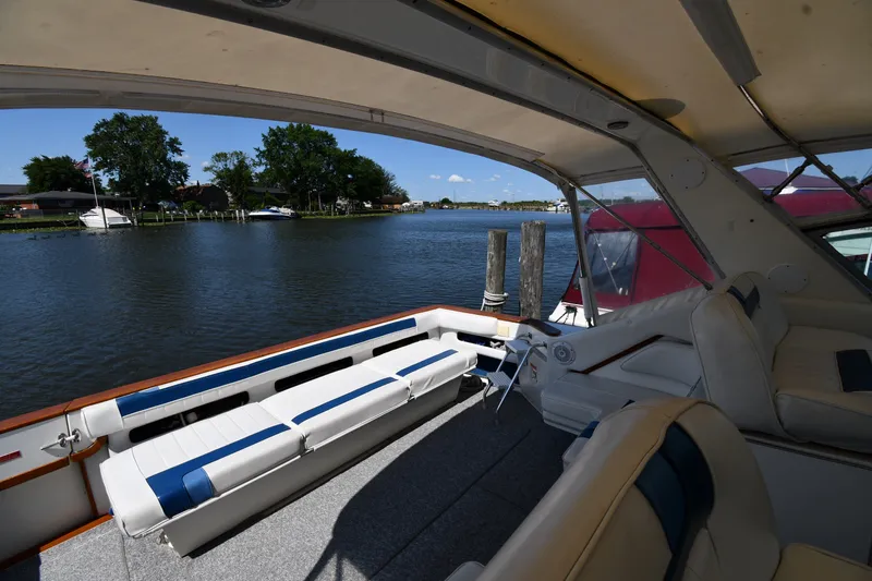 Slide: The Image of 1989 Sea Ray 390 Express Cruiser interior with waterfront view, featuring comfortable seating. - 18