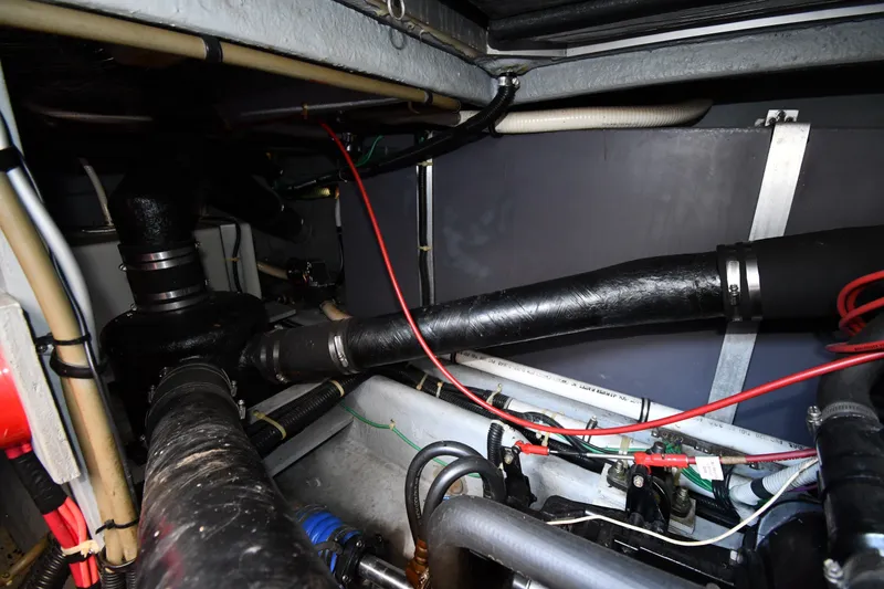 Slide: The Image of Engine room of 1989 Sea Ray 390 Express Cruiser with visible pipes and wiring. - 44