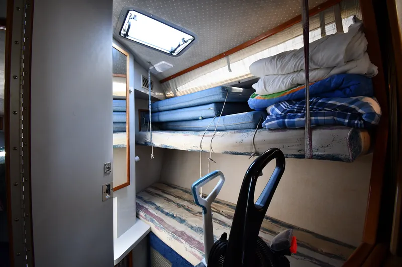 Slide: The Image of Interior cabin of 1989 Sea Ray 390 Express Cruiser with stacked bedding and vacuum. - 31