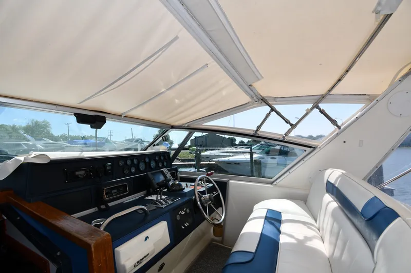 Slide: The Image of 1989 Sea Ray 390 Express Cruiser cockpit with steering wheel, gauges, and seating. - 9