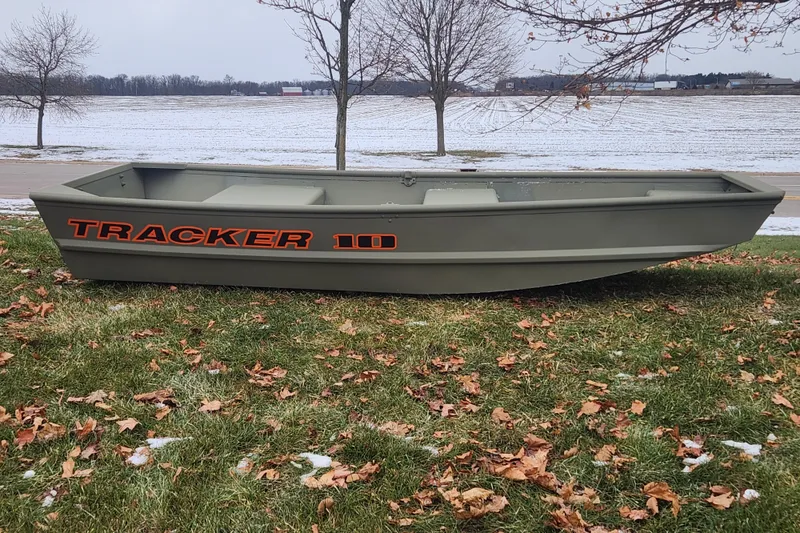 The Image of 2026 Tracker Grizzly 10 Jon boat on grassy field with snowy background. - 0