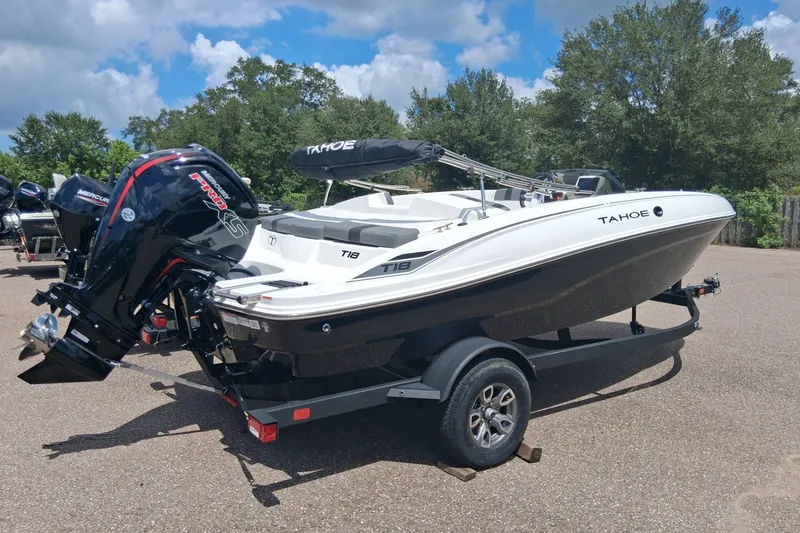 Slide: The Image of 2026 Tahoe T18 boat on trailer, featuring a powerful Mercury engine, parked outdoors. - 1