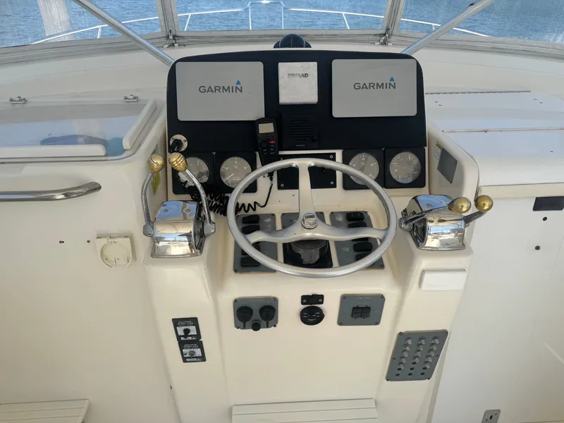 Slide: The Image of The image shows the helm of a 1996 Pursuit 3000 Offshore Express with Garmin electronics. - 13