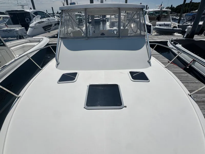 Slide: The Image of A 1996 Pursuit 3000 Offshore Express docked. The deck is clean and spacious. - 20