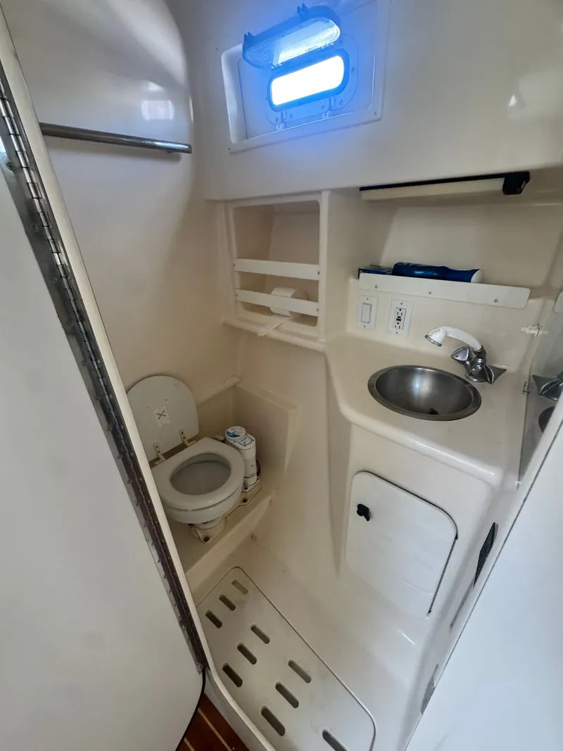 Slide: The Image of The image shows a compact boat bathroom with a toilet, sink, and storage space. - 19