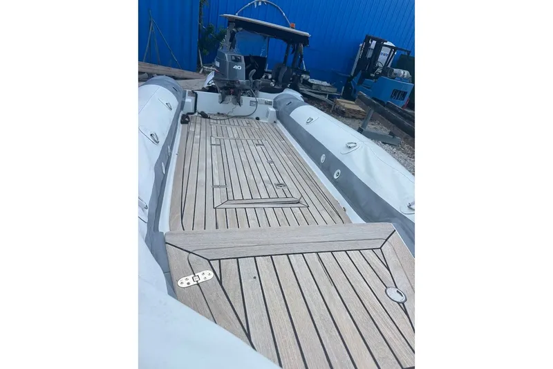 Slide: The Image of Inflatable boat with wooden deck, Embarkation Polymer 2011 model, docked near blue building. - 3