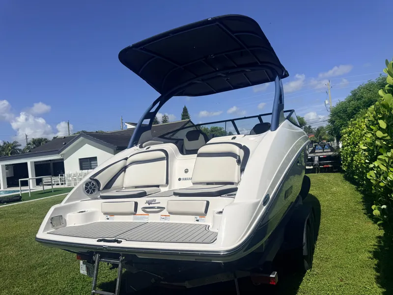 Slide: The Image of A 2020 Yamaha 242SE boat on a trailer in a yard. It features a black canopy. - 4